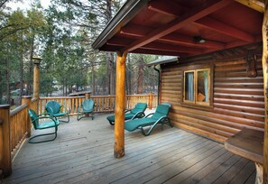 A wooden deck with green lounge chairs and a covered area with a red roof. - Sequoia (Yosemite National Park)