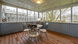 A covered patio with a wooden deck, a round table with chairs, and a grill. - 10 Jill Lane, Cartersville (Cartersville)