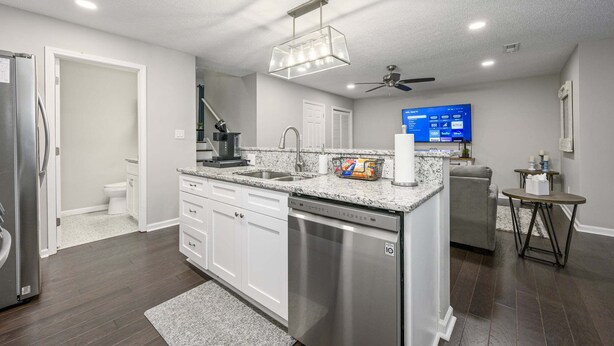 A modern kitchen with white cabinetry, a built-in dishwasher, a granite countertop, and a ceiling fan. - 10 Jill Lane, Cartersville (Cartersville)