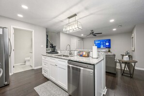 A modern kitchen with white cabinetry, a built-in dishwasher, a granite countertop, and a ceiling fan. - 10 Jill Lane, Cartersville (Cartersville)