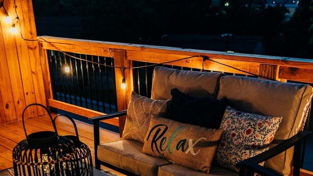 A cozy outdoor seating area with a sofa, a coffee table, and a woven basket.