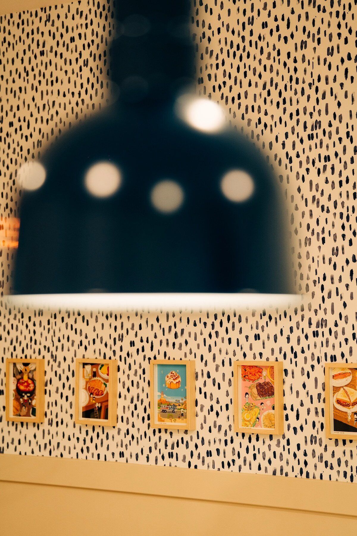 Un mur orné d’un motif ajouré et quatre tableaux encadrés.