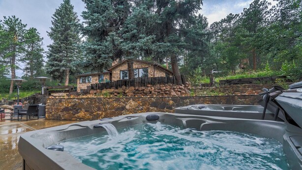 A spa area with hot tubs and a stone building with a wooden deck. - 4925 Pike Unit2 (Cascade)