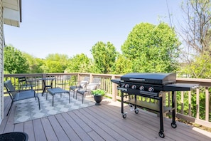 A deck with a grill, outdoor furniture, and a view of trees. - 18 Huntcliff Dr, Cartersville (Cartersville)