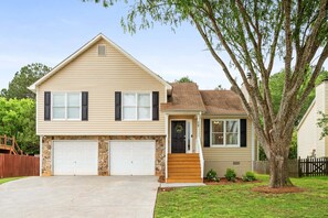 A two-story house with a garage, a front porch, and a tree in the yard. - 13 Huntcliff Dr Cartersville (Cartersville)
