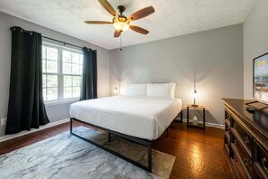 A bedroom with a bed, a ceiling fan, a window with curtains, a nightstand, and a dresser. - 18 Larkspur Ln Emerson (Emerson)