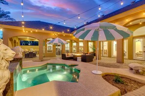 A pool area with a fountain, outdoor seating, and string lights. - Cloud Chandler (Chandler)