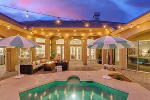 A pool area with a hot tub, umbrellas, and string lights. - Cloud Chandler (Chandler)