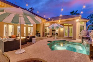 A poolside area with outdoor seating, umbrellas, and string lights. - Cloud Chandler (Chandler)