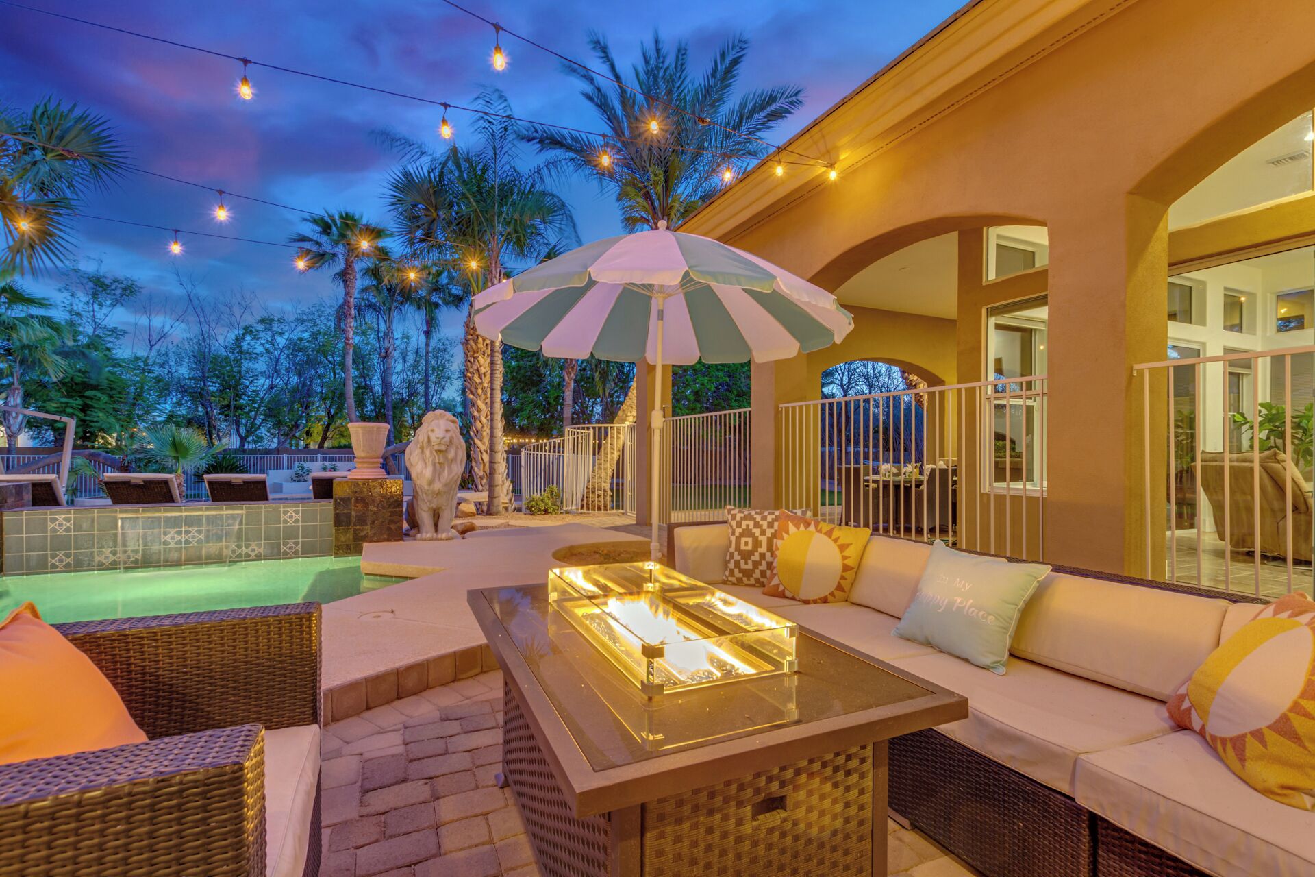 An outdoor patio with a pool, lounge chairs, and a dining area.