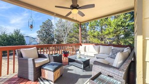 A covered outdoor deck with wicker furniture, a ceiling fan, and a hanging light fixture. - 530 Waterford Drive, Cartersville (Cartersville)