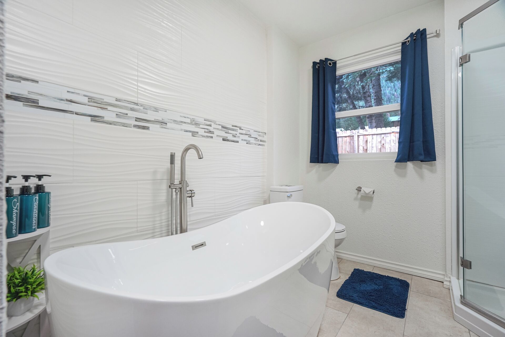 Une salle de bain moderne avec une baignoire sur pieds, des toilettes et un espace douche.