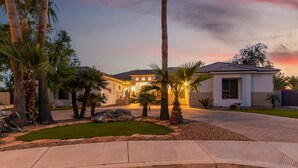 A modern two-story house with a well-maintained lawn and palm trees. - Tonto Chandler (Chandler)