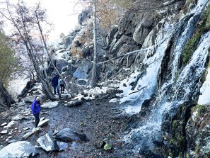 Un paysage rocheux avec une cascade et des randonneurs.