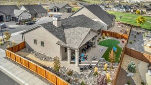 Un quartier résidentiel avec des maisons modernes, un patio couvert et un jardin aménagé.