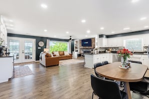 A modern kitchen with white cabinets, a built-in microwave, and a large island.