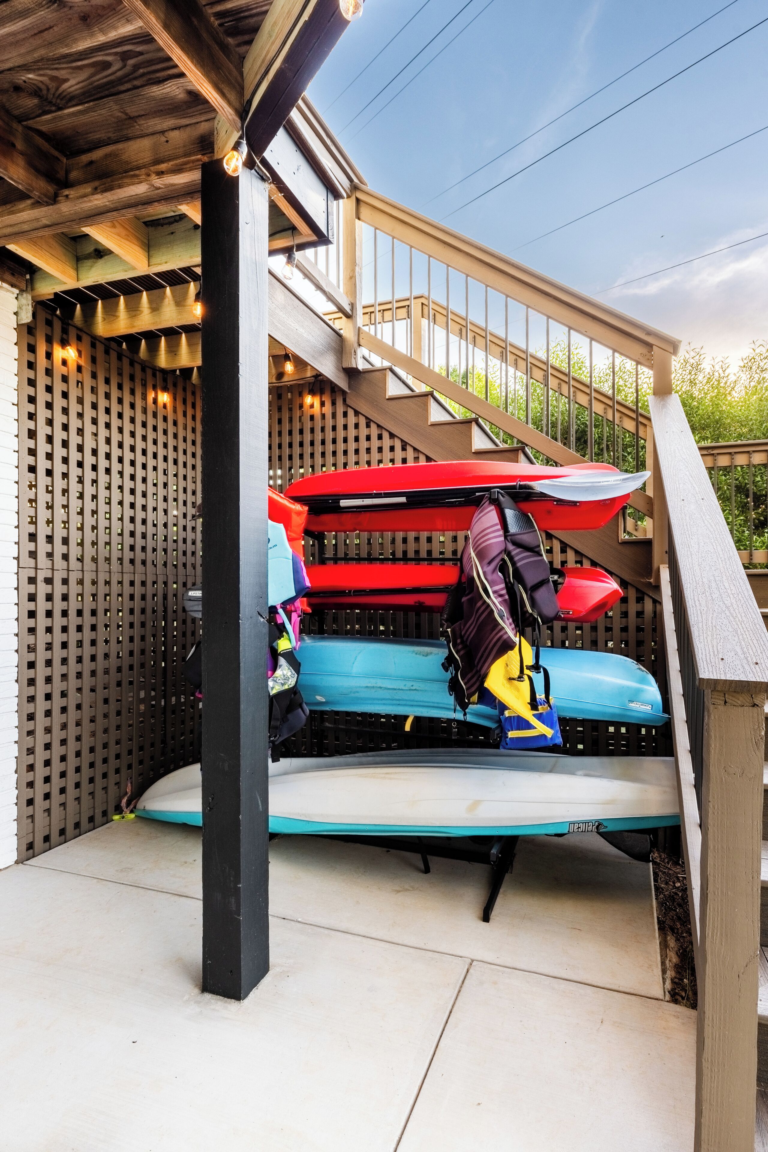 A covered outdoor seating area with kayaks and a black backpack.