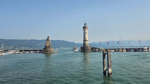 A harbor with a prominent lighthouse and a statue in the foreground. - Penthouse "Pfänderblick" Alpine panorama on Lake Constance near Lindau (Sigmarszell)