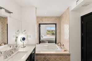 Ein modernes Badezimmer mit zwei Waschbecken, einem großen Spiegel und einer Badewanne.