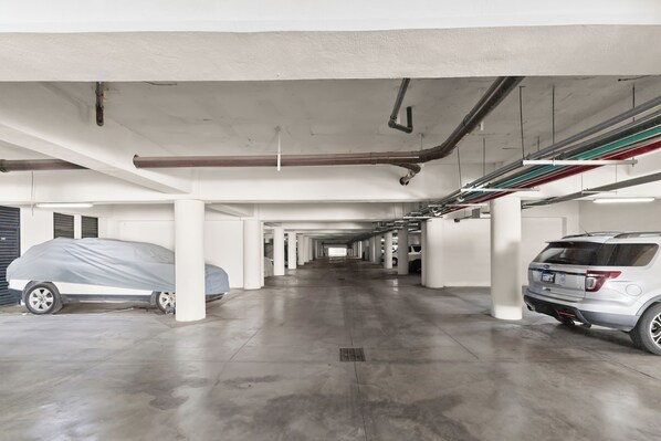 Eine mehrgeschossige Parkgarage mit Betonböden und -säulen, auf der mehrere Autos geparkt sind.