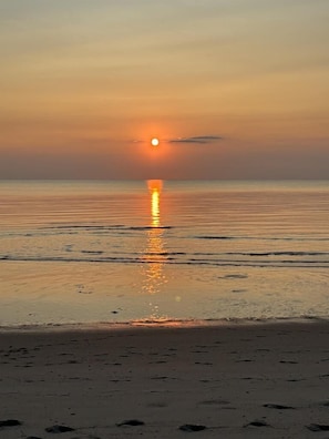 A beach with a sunset over the ocean. - Pool. Close to Beach. Sleeps 11 Guests (Villas)