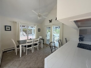 A dining area with a table and chairs, a ceiling fan, and a view through the windows. - Pool. Close to Beach. Sleeps 11 Guests (Villas)