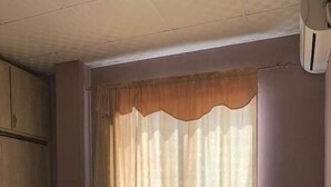 Una camera da letto con un letto, un armadio e una finestra con tende.