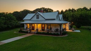 A two-story house with a porch, a chimney, and a well-maintained lawn. - The Bulldog Farmhouse - 100+ Year old Home (Athens)