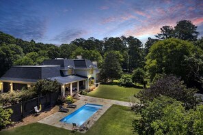 A two-story house with a covered patio, a swimming pool, and a well-maintained lawn. - The Wexford French Chateau w/ Pool (Athens)