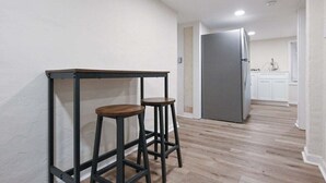 A kitchen with a grey refrigerator, wooden stools, and a white countertop. - Bobbin Mills Studio - 1 Mile From Downtown Athens (Athens)