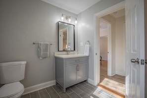 Un baño con inodoro, tocador y espejo.
