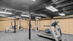 A gym with exercise equipment, a treadmill, and a weight bench. - Classic City Getaway at Stadium Village (Athens)