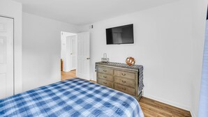 A bedroom with a bed, dresser, and TV. - Classic City Getaway at Stadium Village (Athens)