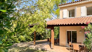 A two-story house with a patio area, a dining table, and chairs. - Amazing home in Montauroux with swimming pool (Montauroux)