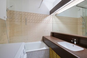 Ein modernes Badezimmer mit Badewanne, Waschbecken und Dusche.