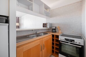 A compact kitchen with a sink, a toaster, a coffee maker, and an oven. - AS26823- P2 City Center - Side Sea View (LE GRAU DU ROI)