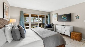 Habitación de hotel con cama, televisión, escritorio y vista al exterior.