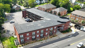 A multi-story building with a flat roof, parking lot, and a street view. - The Lofts of Downtown 540 N 2nd St, #207 (Clarksville)