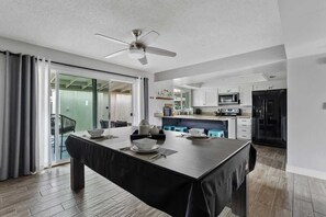 A modern kitchen with a dining area, featuring a large island, built-in appliances, and a ceiling fan. - Artsy Townhouse w/ Billiards & King En Suite (Phoenix)