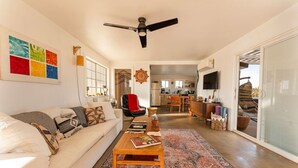 Sala de estar com sofá, mesa de centro e vista para a cozinha.