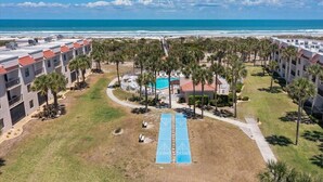 Ein Resort mit Pool, Palmen und Blick auf den Strand.