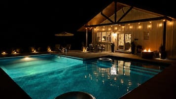 A swimming pool with a lounge area and a building with a covered patio.