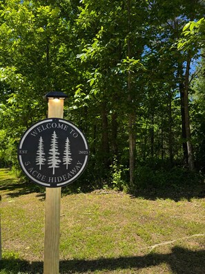 A circular welcome sign with a forest scene, established in 2025, and a solar light fixture above it. - Private Pool Retreat- Fire Table + Country Escape in Cleveland TN (Cleveland)