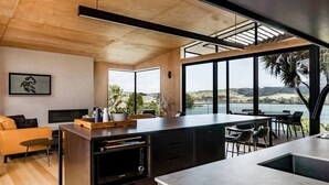 Una cocina moderna con una isla grande, muebles de madera y vistas al exterior.