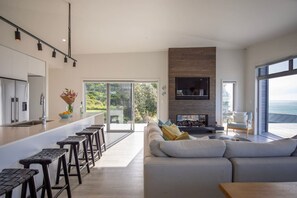TV, fireplace - Ocean Beach Retreat • Stylish Prime Beachfront (Raglan)