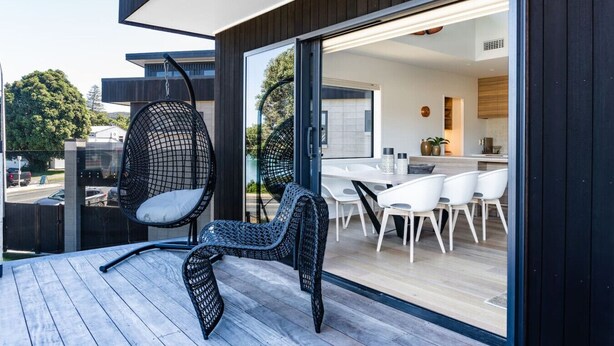 Ein moderner Außenbereich mit Korbstühlen und einer Holzterrasse.