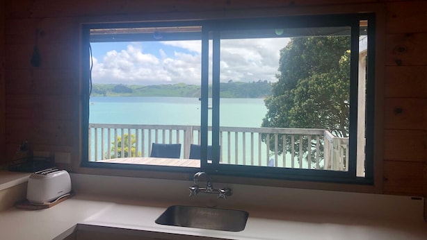 Cocina con un amplio ventanal con vistas a un lago y una terraza.