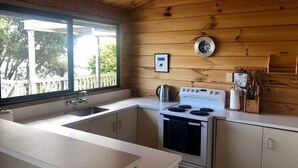 Una cocina con estufa, lavaplatos y ventana.