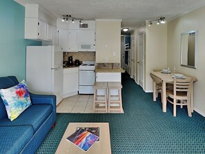 A compact living space with a kitchenette, a dining area, and a seating area. - Casa Del Mar 124 (Galveston)