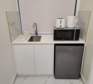 A compact kitchenette with a sink, microwave, and dishwasher. - Family Room Victor harbor (McCracken)